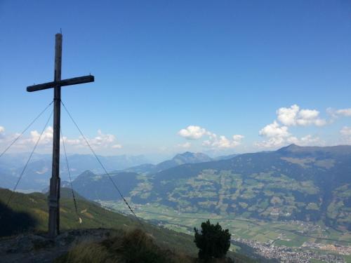 a cross on top of a hill with a view at Ferienhof Kampfl in Fügen