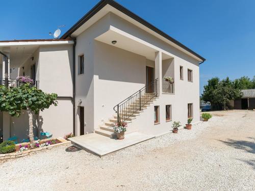 a white house with stairs and potted plants at Apartment Stefano - free wine&spirit tasting in Višnjan