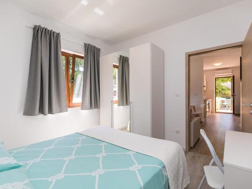 een slaapkamer met een bed met een blauwe sprei bij Apartment Stefano - free wine&spirit tasting in Višnjan