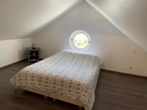 a bed in a room with a small window at CASABINA Appartement entre Disney et paris in Chelles
