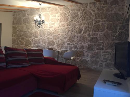 een slaapkamer met een bank en een stenen muur bij Villa Marija in Vrsar