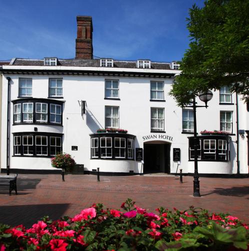 a large white building with flowers in front of it at The Swan Hotel, Stafford, Staffordshire - The Coaching Inn Group in Stafford