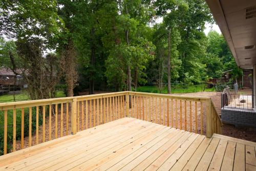 a wooden deck with a fence and some trees at Luxury Home w/GameRoom KingSizeBed near Six Flags in Austell
