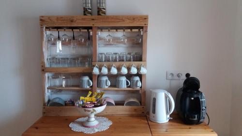 a shelf with cups and a bowl on a table at Apibus Domus - Chris et Stèph in Guillaumes