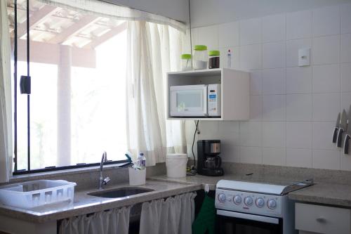 a kitchen with a sink and a stove and a window at Casas em Ilhabela, Linda vista, praia Itaguaçu, Vila Paulino, Colibri, Tuim e Tucano in Ilhabela