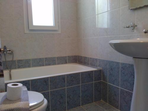 a bathroom with a tub and a toilet and a sink at Liberatos Village in Lassi