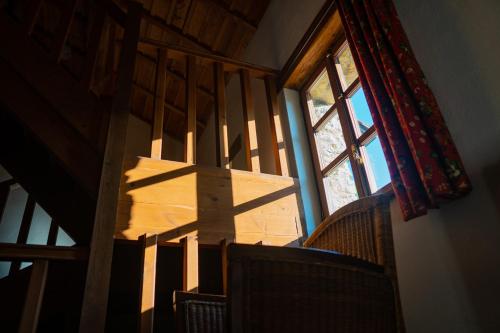 a stairway with a window and a shadow on the stairs at La Montaña Mágica Hotel Rural in Vibaño