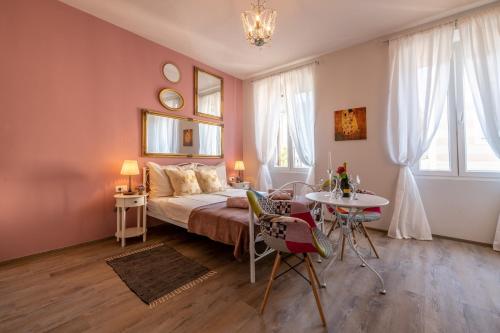 Schlafzimmer mit einem Bett und einem Tisch mit Stühlen in der Unterkunft Old City Romantic Studios 3 in Pula
