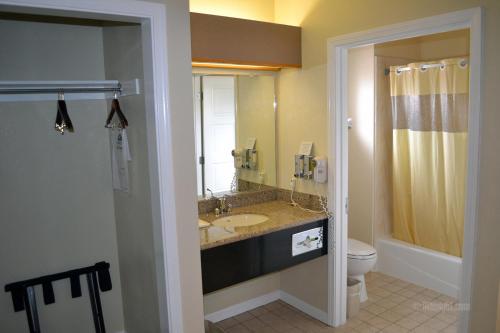 a bathroom with a shower, sink, and mirror at The Miramar Inn & Suites in Half Moon Bay