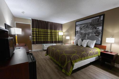 a hotel room with a bed and a flat screen tv at Super 8 by Wyndham Goldsboro in Goldsboro
