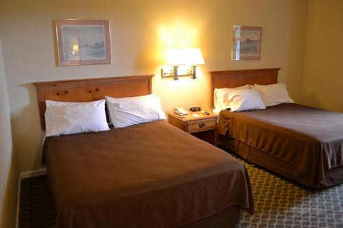 a hotel room with two beds and two lamps at The Miramar Inn & Suites in Half Moon Bay