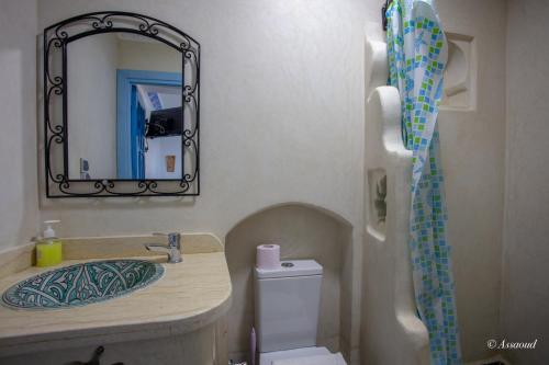 a bathroom with a sink and a mirror and a toilet at Puerta Azul in Chefchaouene