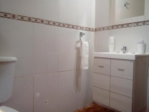 La salle de bains blanche est pourvue d'un lavabo et de toilettes. dans l'établissement IGUAZU CABANAS, à Puerto Iguazú
