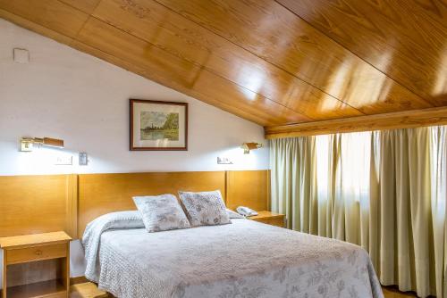 A bed or beds in a room at Hotel Sierra de Aracena