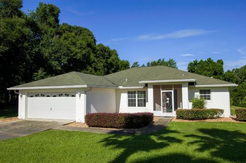 a white house with a green roof at North Timucuan Trail Villa 1208 in Hernando