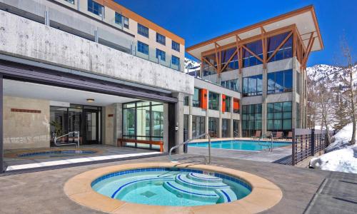 a building with a swimming pool in front of a building at Alta's Rustler Lodge in Alta
