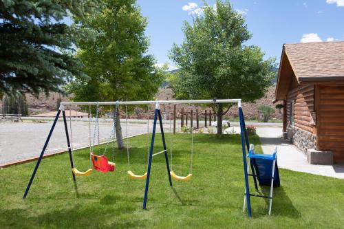 a swing set in a yard with green grass at Super 8 by Wyndham Dubois in Dubois