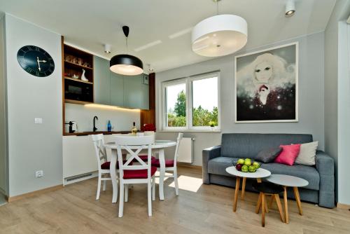 a living room with a couch and a table at BlueApart Apartamenty Na Klifie in Władysławowo