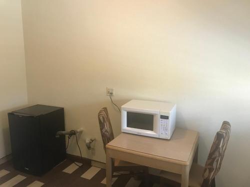 a microwave sitting on top of a table with chairs at All 8 Motel in Long Beach