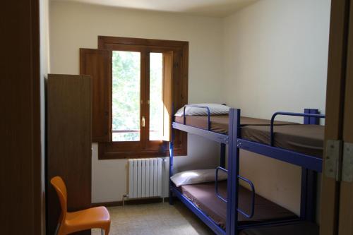 Habitación con 2 literas y ventana en Alberg Roques Blanques en Ribes de Freser