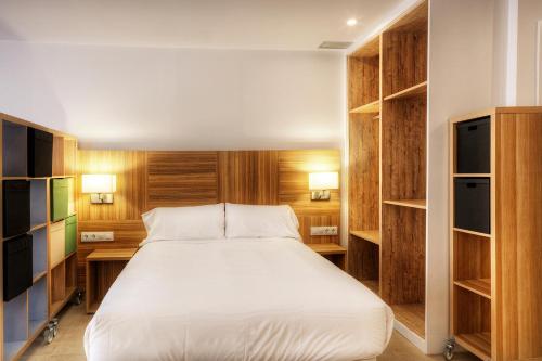 a bedroom with a large bed and wooden shelves at Apartaments Lauria in Tarragona