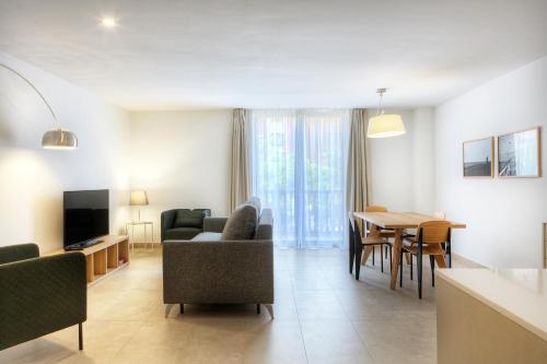 a living room with a couch and a table with chairs at Apartaments Lauria in Tarragona