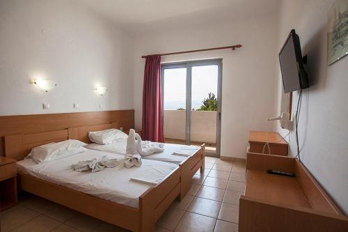 a bedroom with a bed with towels on it at Apostolis Hotel Apartments in Pefki