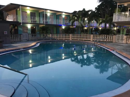 una gran piscina frente a un hotel por la noche en Tropical Inn & Suites, downtown clearwater, en Clearwater