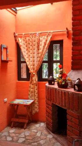 a living room with a fireplace and a curtain at HOSTAL CABAÑAS AVE MARIA in Concepción de Ataco