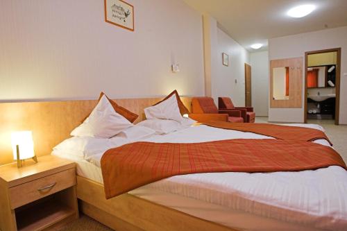 a bedroom with a large bed with a red blanket at Völgyikút Ház in Veszprém