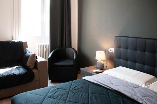sypialnia z łóżkiem, krzesłem i lampką w obiekcie Fiera Boutique w Bolonii