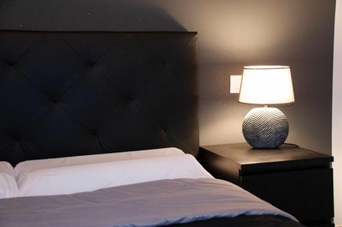 a bedroom with a bed and a lamp on a night stand at La boutique fronte fiera in Bologna