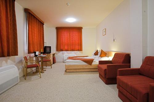 a hotel room with a bed and a couch at Völgyikút Ház in Veszprém