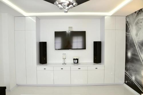sala de estar con armarios blancos y TV de pantalla plana en Apartament Pegaz, en Gniezno