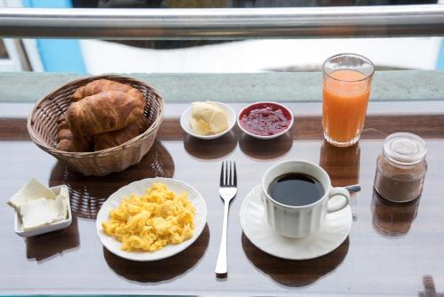 Una mesa con alimentos para el desayuno y una taza de café. en Hostal Dulce Amanecer, en Baños