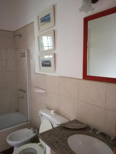 a bathroom with a toilet and a sink and a mirror at La Caballeriza in La Granja