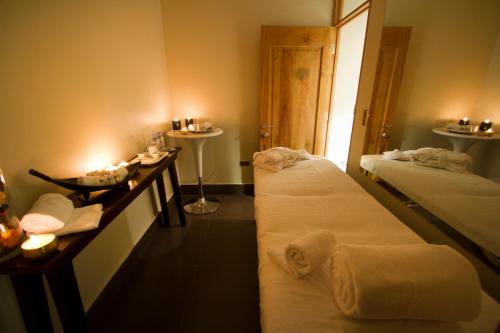 2 camas en una habitación con velas y toallas en Casa Bueras Boutique Hotel, en Santiago