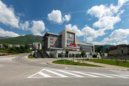 a building with a clock on the side of a road at Hotel IUT in Travnik