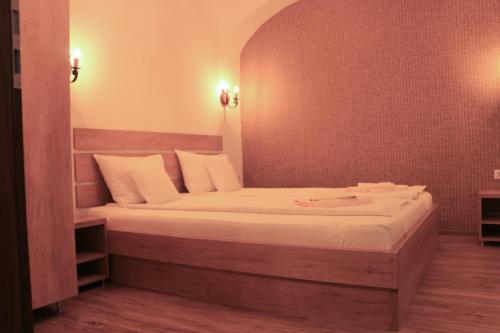 Corso Comfort Apartments في سيبيو: غرفة نوم بسرير كبير مع شراشف بيضاء