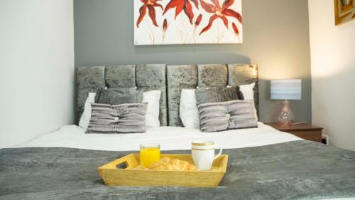 a tray of bread and drinks on a bed at Comfort Stay Apartments in Birmingham