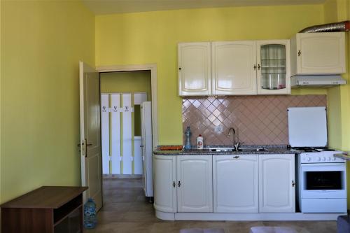 Cozy new apartment Velipoja في فيليبوجي: مطبخ بجدران صفراء ودواليب بيضاء