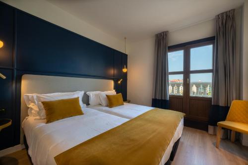 a bedroom with a large bed and a large window at Puente Colgante Boutique Hotel in Portugalete
