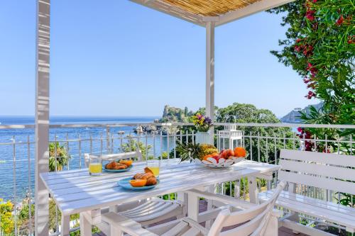 a table with fruit and drinks on a balcony with the ocean at Paradisea Taormina in Taormina