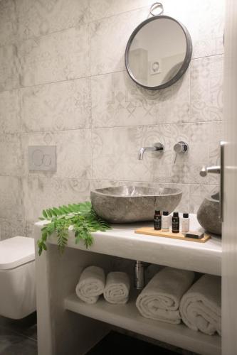 a bathroom with a sink and a mirror and towels at Kissos Luxury Suites in Naxos Chora