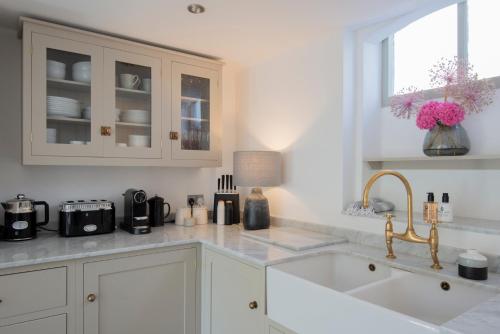 a kitchen with white cabinets and a sink and a window at A Luxury Retreat in the Heart of Arundel in Arundel