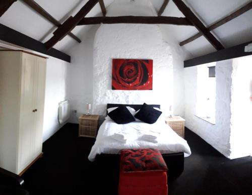 a bedroom with a bed and a red painting on the wall at The Star Inn in Saint Erth