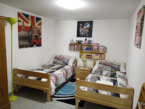 a bedroom with two beds and a book shelf at Le Ruchoz in Lausanne