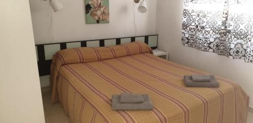 a bedroom with a bed with two towels on it at Casa y Estudio Keyfer, Arrecife Centro in Arrecife