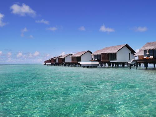 a row of huts on the water in the ocean at The Residence Maldives in Gaafu Alifu Atoll