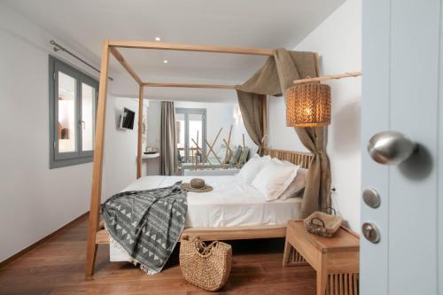a bedroom with a canopy bed in a room at Kissos Luxury Suites in Naxos Chora
